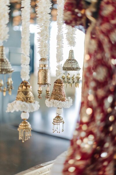 Traditional indian decorations featuring floral garlands and bell-shaped ornaments hanging indoors.