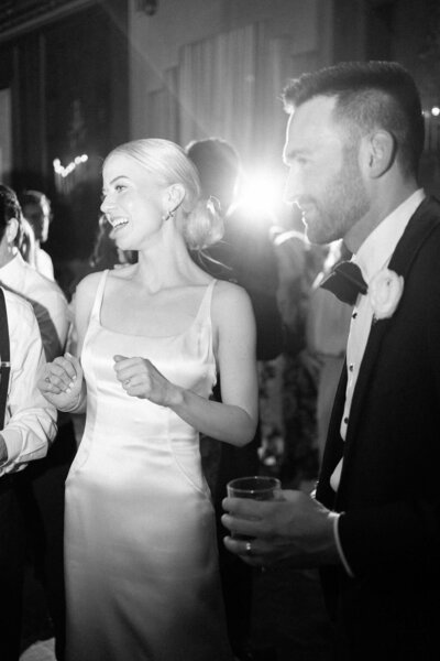 Bride standing in rain with umbrella in a vintage wedding gown with white lace umbrella taken by wedding photographers chicago Allison Francois Photography