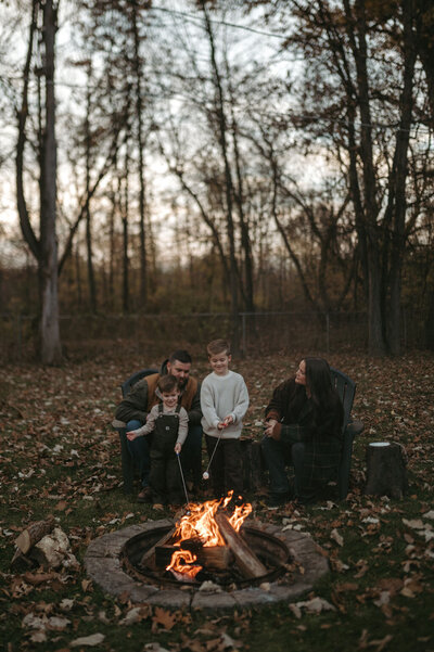 Paige Rini and her family gathered around a campfire in the woods during an outdoor session