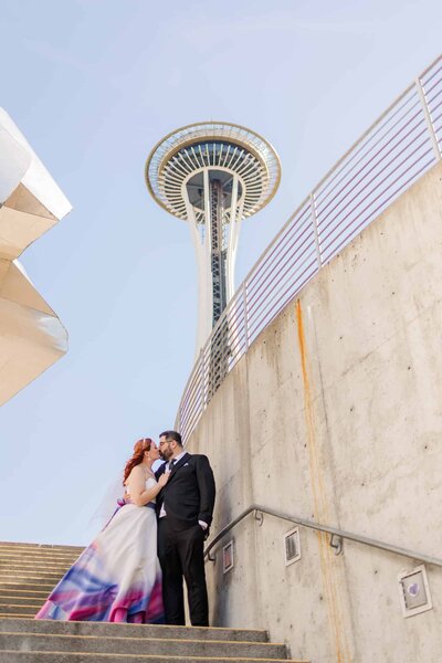 Bride and groom, kissing, with the beautiful space needle in the background