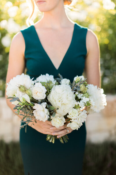 destination wedding bride holding all white floral bouquet with olive branch touches