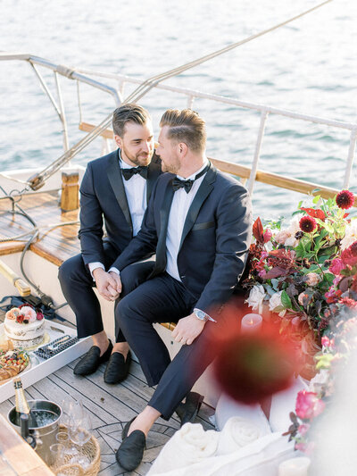 two grooms state into eac hother's eyes on a yacht