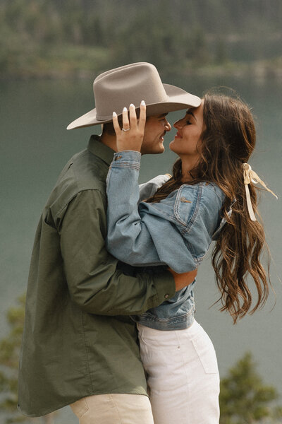 couple embrace and smile at st mary's lake in glacier national park