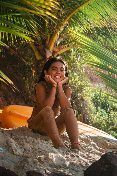 girl sat under palm in hawaii