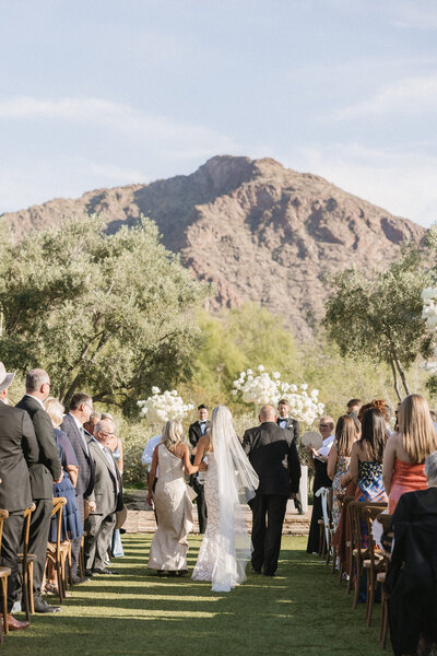 Bride walking down aisle with parents at El Chorro wedding ceremony