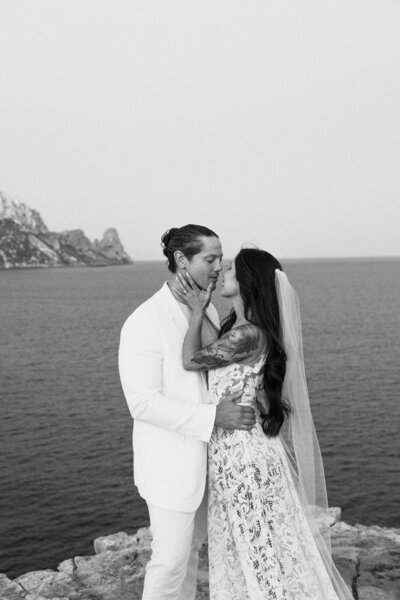 Couple is almost kissing during their wedding for a photographer with Es Vedra in the Background