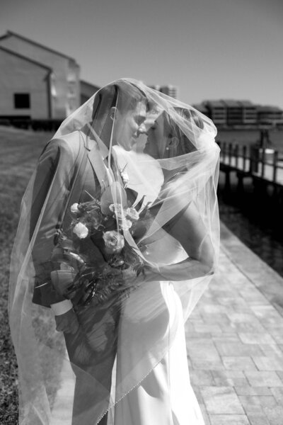 Wedding portraits with veil around them in blueberry field