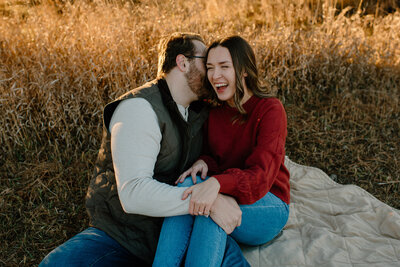 man whispering in his fiancé's ear