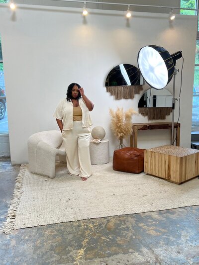 woman in white suit standing in front of a photography light-box