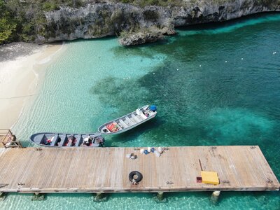 boats docked at small beach with turquoise water