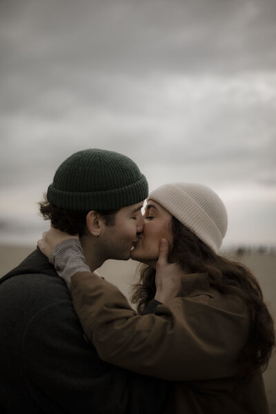Madison and Lucas share a kiss on cannon beach in oregon