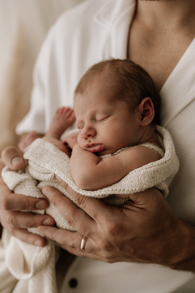 Newborn Photography, close up of baby sleeping in mother's arms