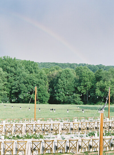 Outdoor farm wedding reception with rainbow designed by East Made Co
