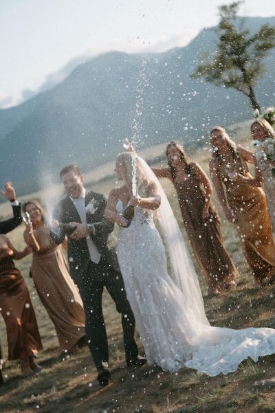 Newly wed couple celebrating their special day with loved ones and pop a wine