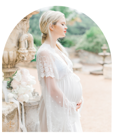 Woman in white robe closing eyes in a maternity portrait.
