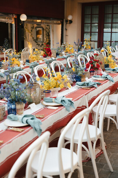 Black and white photo of a Bastide de Gordes wedding dinner featuring a long, rectangular table, soft candlelight and medieval architecture