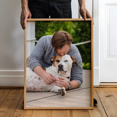 Woman hanging framed artwork of dog 