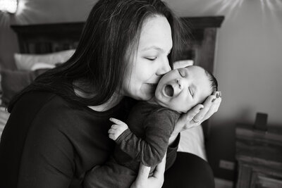 Mom kissing newborn son in Elmhurst, IL by Taylor Lynn Studios