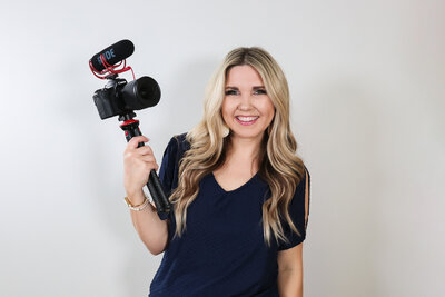 woman smiling holding a camera