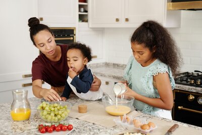 Mom and her two kids in the kitchen eating healthy food. 