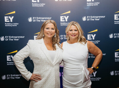 Chanda and Christa in front of the Entrepreneur of the Year step and repeat
