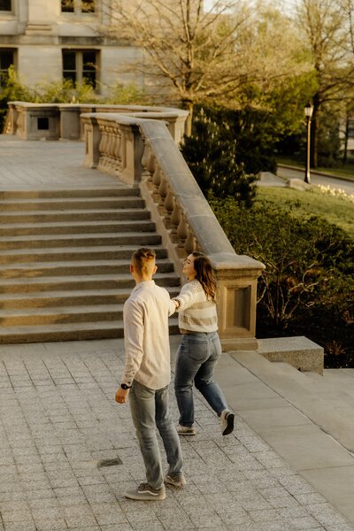 A young couple dances in the golden hour sun in Iowa City, Iowa.