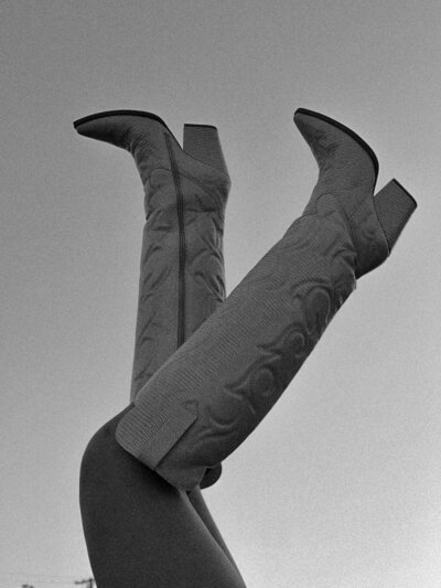 Woman's legs up in the air wearing cowgirl boots