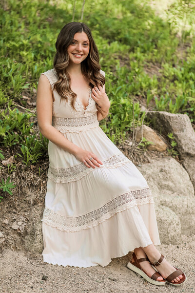 Girl sitting in white dress and brown sandals | Senior Photography Session taken by Maine Photographer