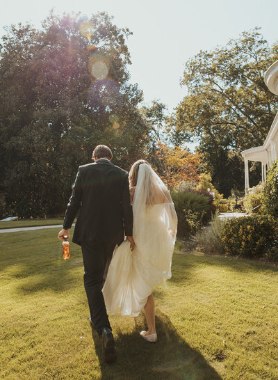 couple holding hands walking into their wedding reception
