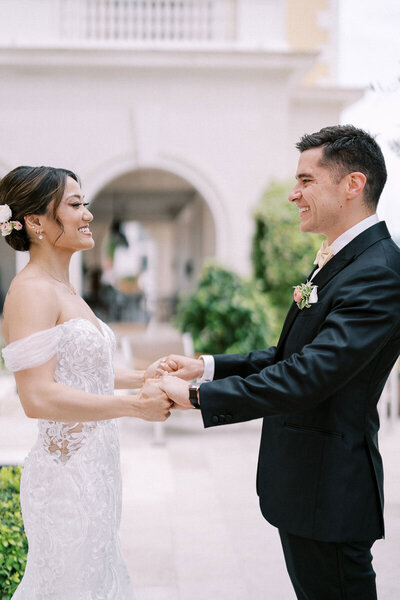 Groom and bride holding hands during first look, smiling and laughing on wedding day in Montenegro, captured by Toronto wedding photographer