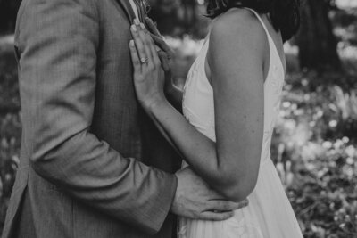 Black and white of bride and groom's arms embracing