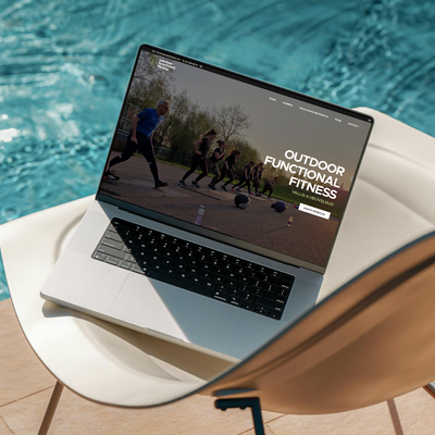 Vrouw achter laptopt werkt aan Showit websites vanaf het zwembad