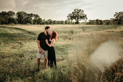 Romantic outdoor portrait of Shannon and Rene embracing in a Minnesota field, featured in their love story on Deaf inclusion and resilience.