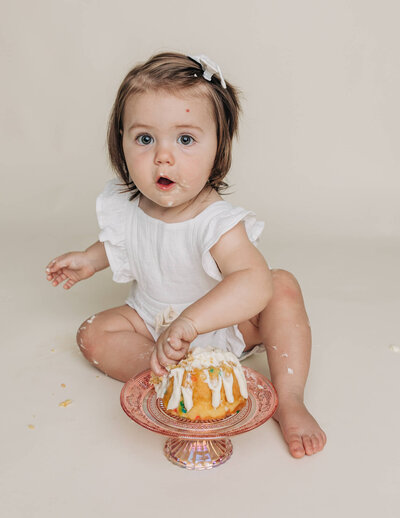 Baby looking at camera with birthday cake