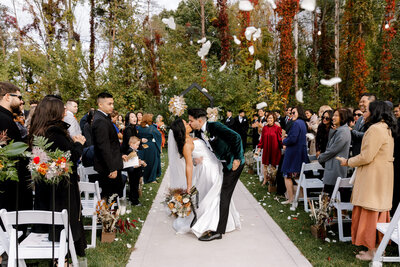 bride and groom dip kissing in the aisle after their michigan wedding