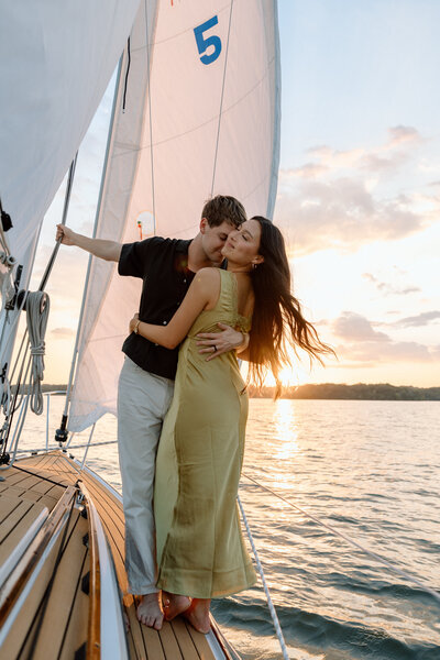 couple embracing on a sailboat at sunset