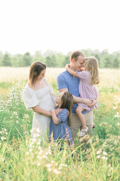 Expecting parents standing in a field of wildflowers for their Louisville maternity photos