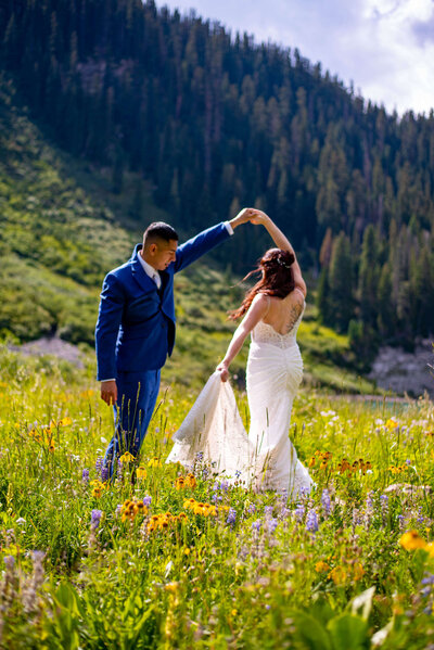 A bride and groom dance in a field of wildflowers during their Colorado elopement.