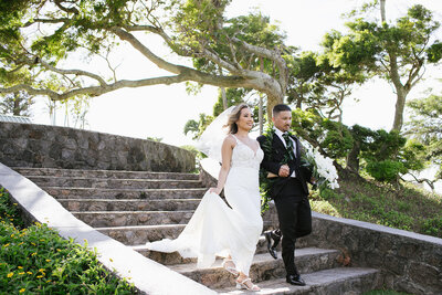 Bride and groom walk down stairs holding hand at the maui pineapple chapel 