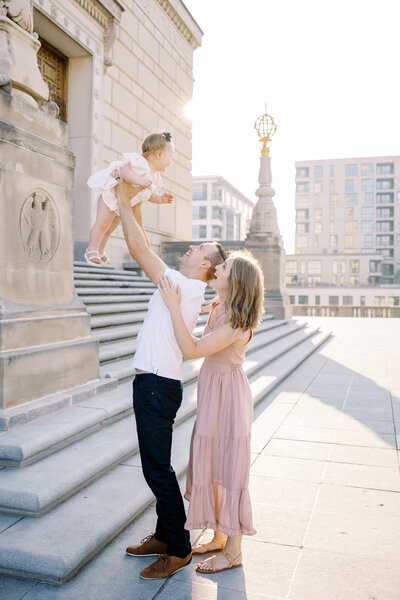 dad throwing toddler up in the air during a sunrise family session