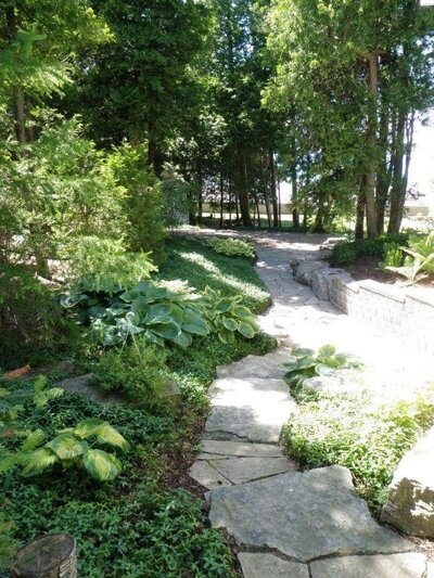 Garden maintenance with custom stone pathway and gardens by Helena's Garden