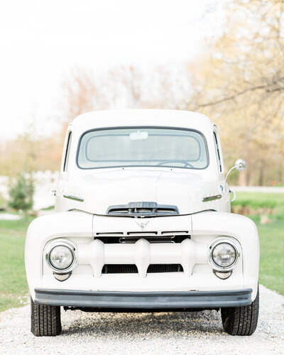 A white vintage Ford truck sitting on a white path at Jennifer Hall Photography, LLC in North East, PA.