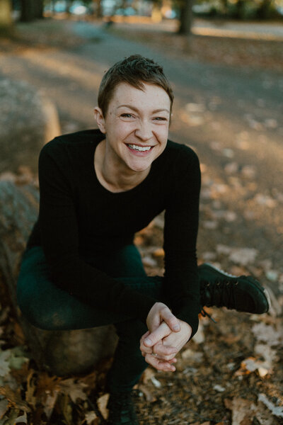 woman in park sitting on bench and smiling