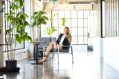 woman sitting on black chair in large bright office space