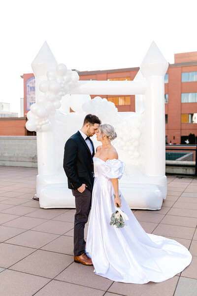 White wedding bounce house inflatable with organic balloon garland