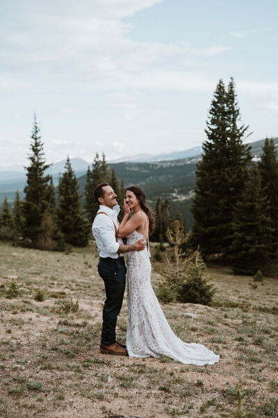 Bride and groom laughing during candid moment at mountain elopement in Breckenridge.