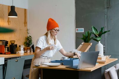 Woman in orange hat unwrapping package