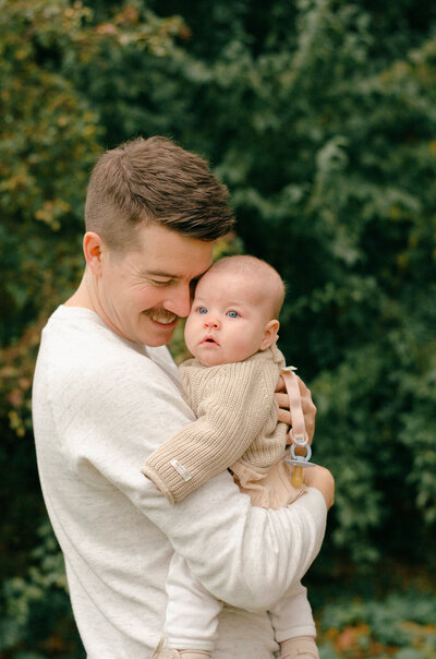 Father and daughter cuddle in a park in Amsterdam, during a photoshoot.