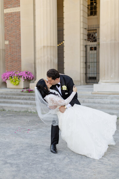 Veil shot of bride and groom snuggling close together in front of a barn door