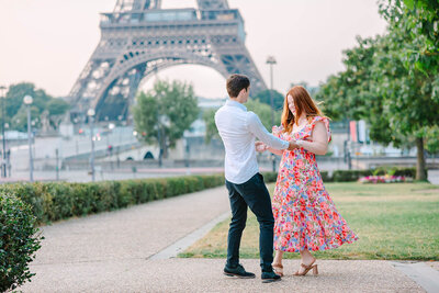 Couple dancing near the Eiffel Tower at Trocadéro and along the Seine — man in a shirt and woman in a flowing dress during a romantic Paris couples photoshoot.